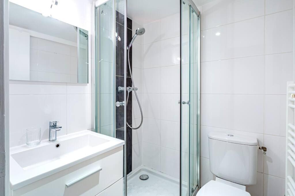 a bathroom with a shower and a toilet and a sink at Appartement Avenue Philippe Auguste in Paris