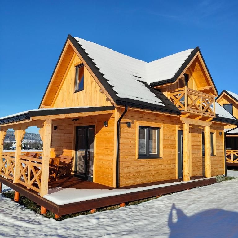 Cabaña de madera con nieve en el techo en beskid.house1, en Spytkowice