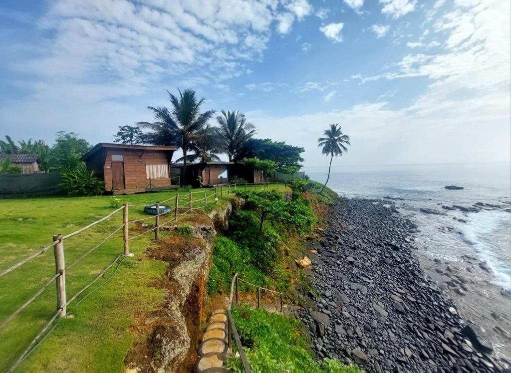 a house on the shore of a rocky beach at GENTE D'AQUI Ngê D'ai êê in São Tomé