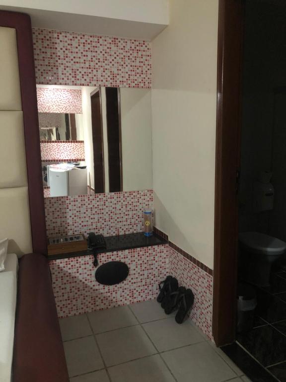 W łazience znajduje się umywalka i lustro. w obiekcie Motel Las Vegas - Colatina w mieście Colatina