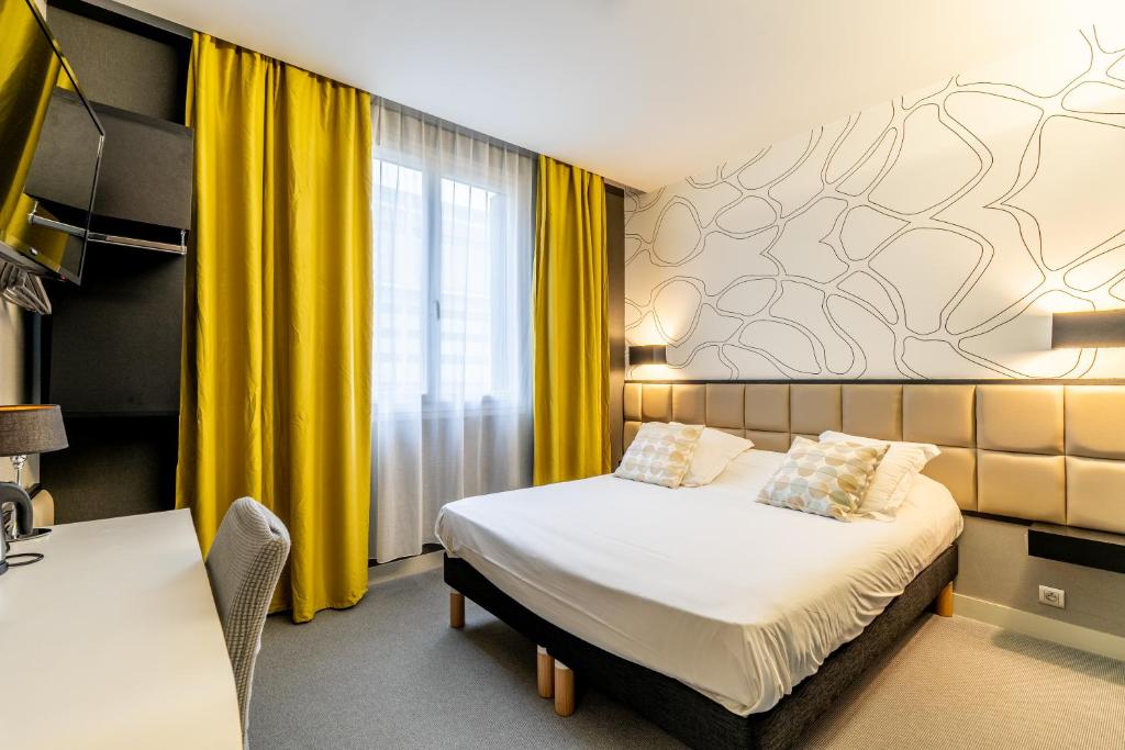 um quarto de hotel com uma cama e uma cortina amarela em Hôtel Astoria em Nantes