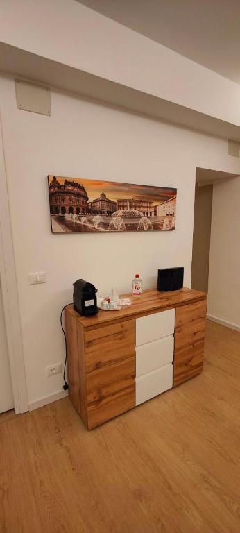 a room with a wooden dresser with a picture on the wall at Affittacamere Le Vele in Genoa