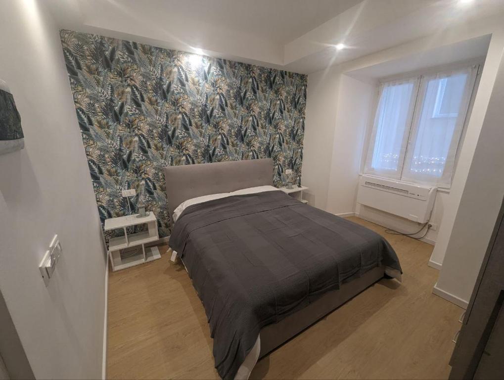 1 dormitorio con 1 cama y un mural en la pared en Affittacamere Le Vele, en Génova