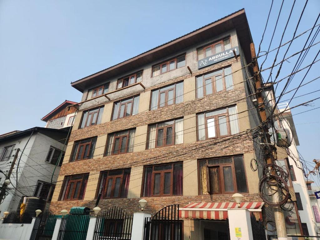 a tall brick building with windows on a street at Abdullah Residency in Srinagar