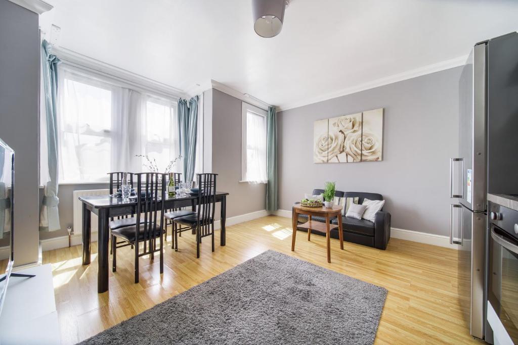 a living room with a table and chairs and a couch at Two Bedroom Apartment in London Harlesden in London