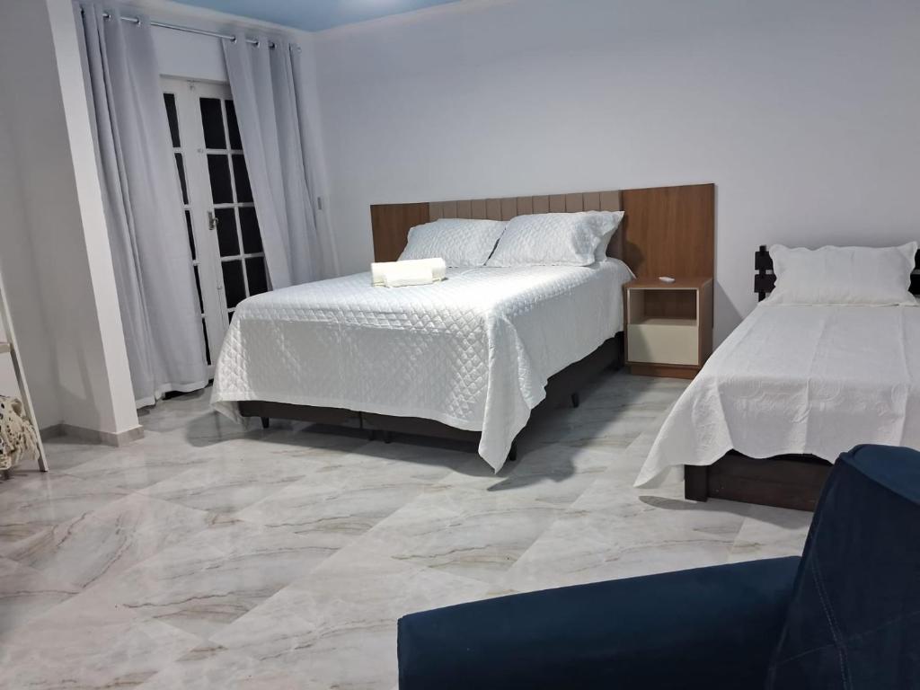a bedroom with two beds and a tile floor at Pousada belo sol in São Pedro da Aldeia
