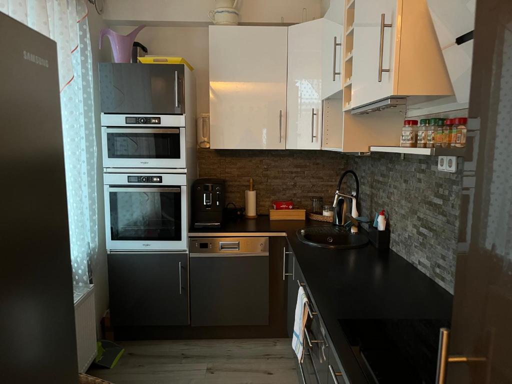 una cocina con armarios blancos y fregadero en Saunaga korter Tapa kesklinnas!, en Tapa