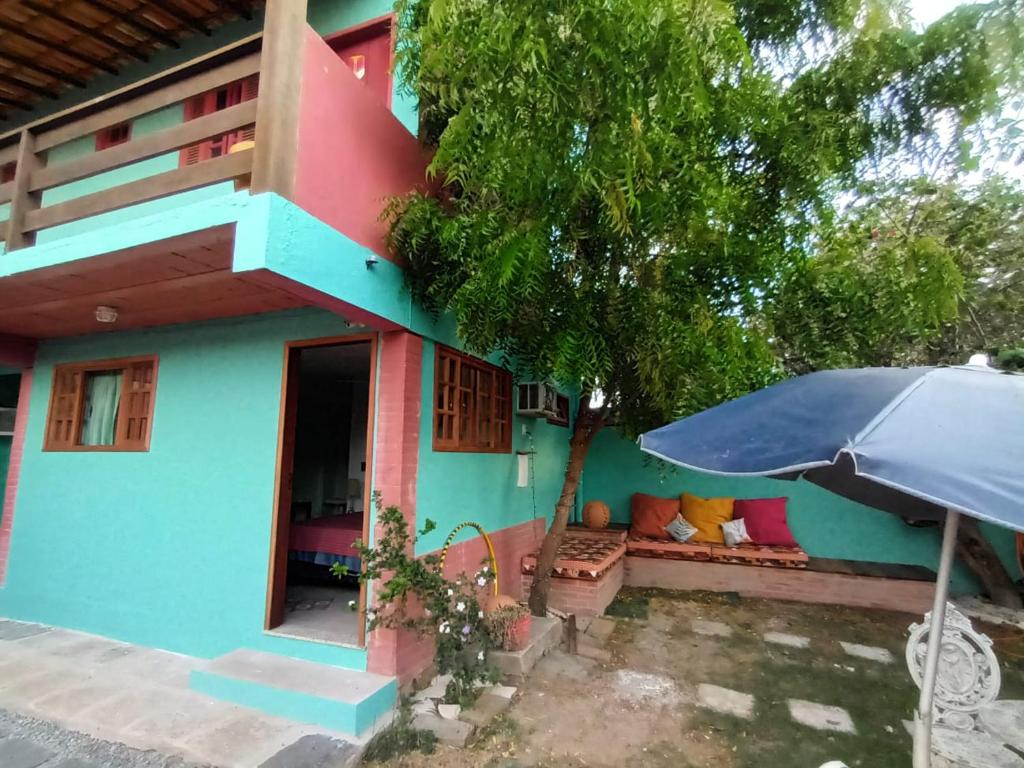 a blue house with an umbrella in front of it at Bee My Guest in Búzios