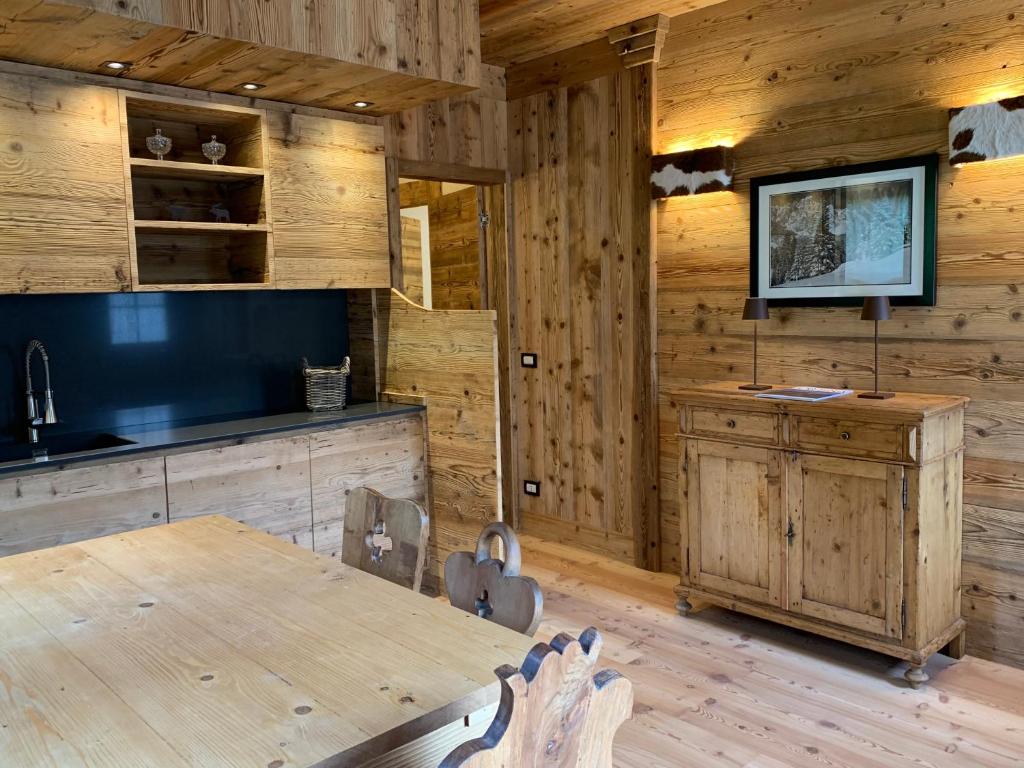 a kitchen with wooden walls and a table and a television at Piccolo gioiello di montagna in Villanova