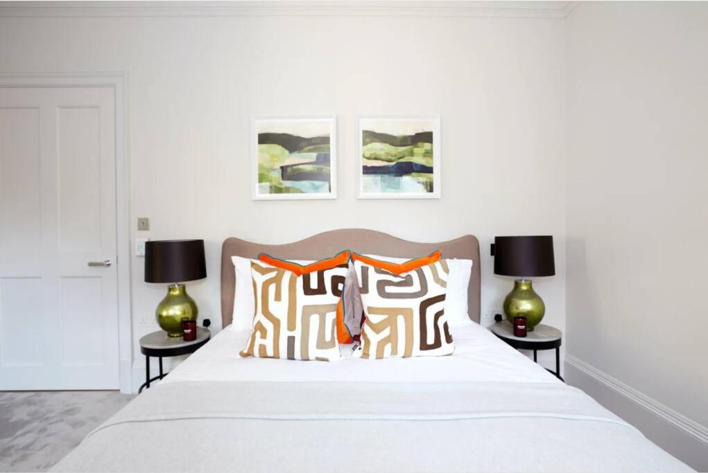 a bedroom with a white bed with two lamps at Modern & Private Belgravia Apartment - Sleeps 4 in London