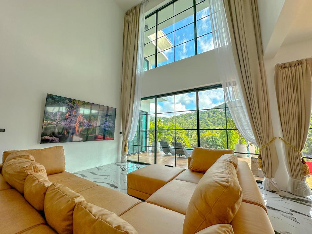 un salon avec un canapé et une grande fenêtre dans l'établissement Reggae Garden Villas, à Salad Beach