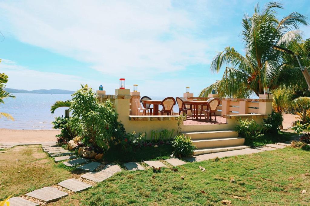 une maison avec une table et des chaises sur la plage dans l'établissement Southdrive Beach Resort, à Bulalakao