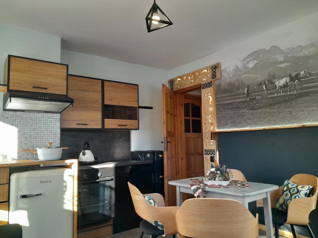a kitchen with a table and chairs in a kitchen at Apartamenty Wierch 17 in Kościelisko