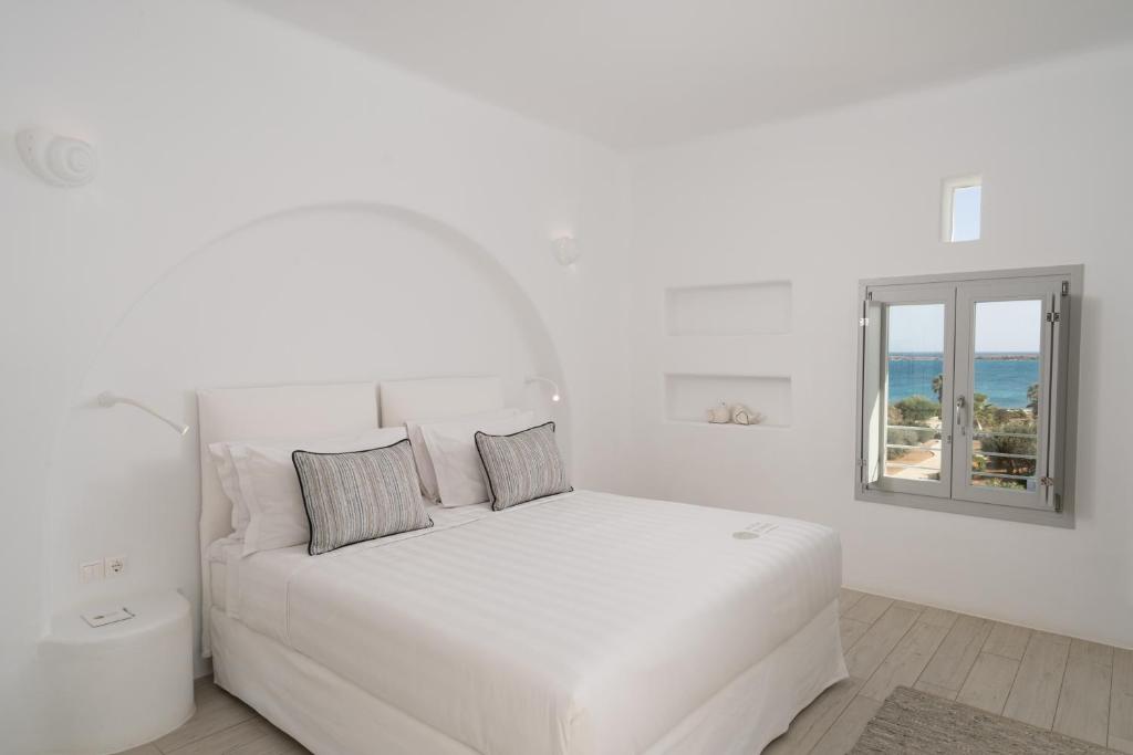 a white bedroom with a white bed and a window at White Dunes Luxury Boutique Hotel in Santa Maria