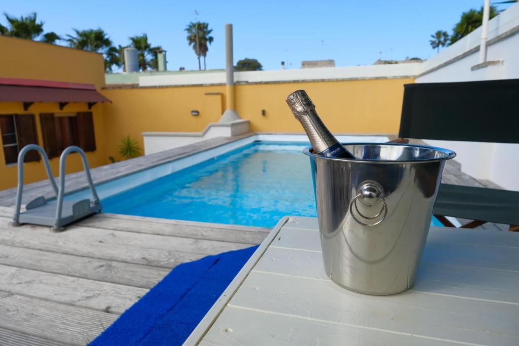 un seau avec une bouteille dedans à côté d'une piscine dans l'établissement Villa Oasi al mare near the sea with pool - Happy Rentals, à Melendugno