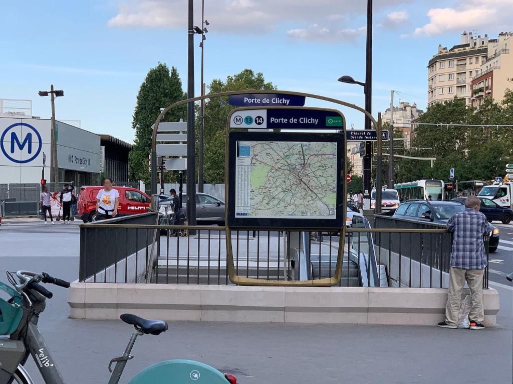 a man standing at a bus stop with a map at LOGEMENT CLICHY in Clichy