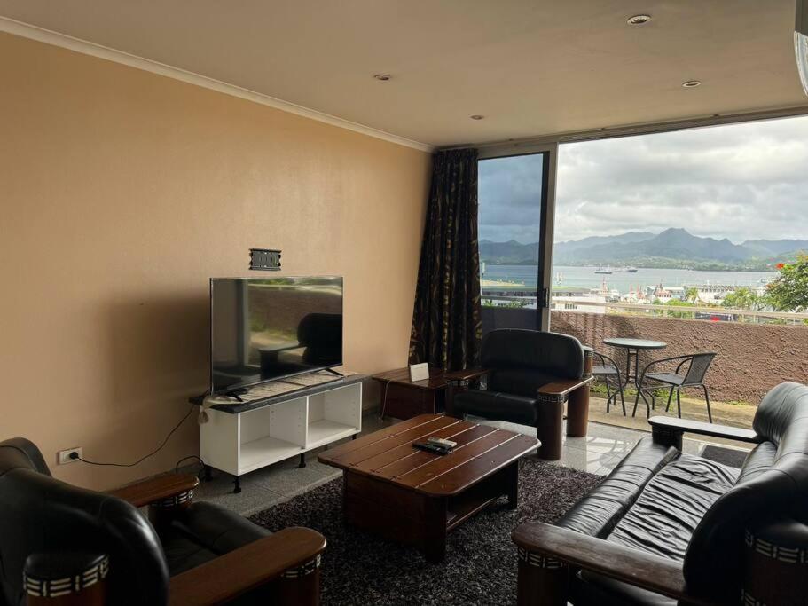 a living room with a tv and a couch and a table at SBs Apartment in Suva