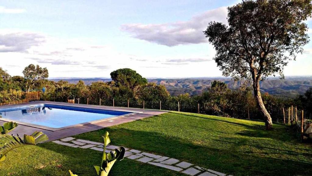 a swimming pool in the middle of a grassy yard at Quinta da Idalina in Monchique