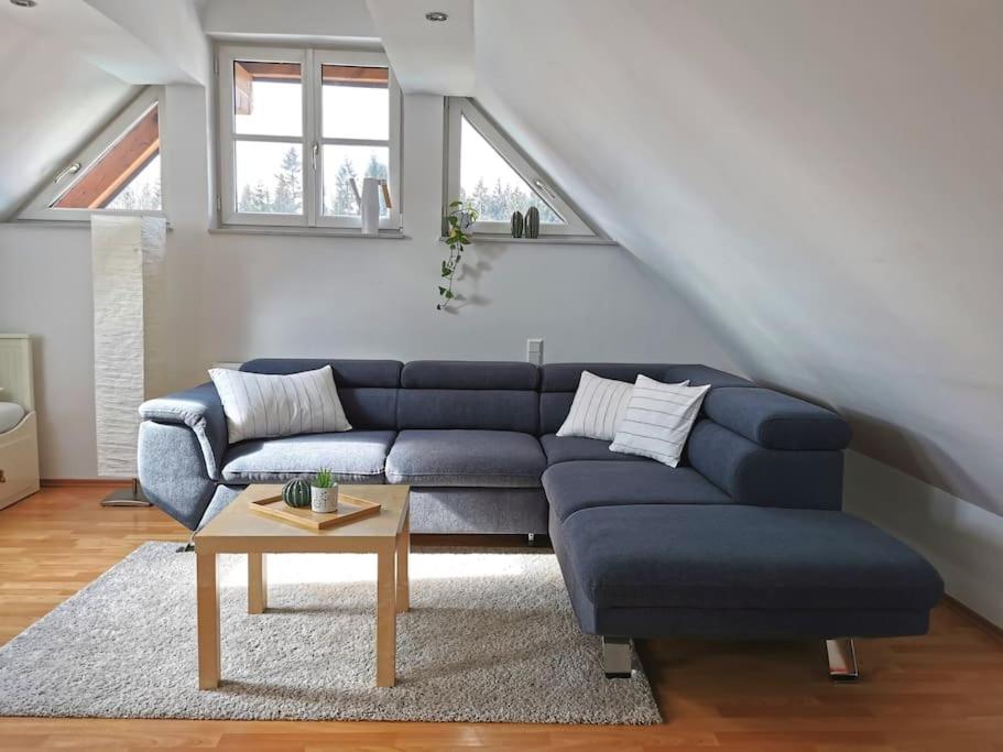 a living room with a blue couch and a table at Ruhige 3-Zimmer-Wohnung am Stadtrand mit Bergblick in Salzburg