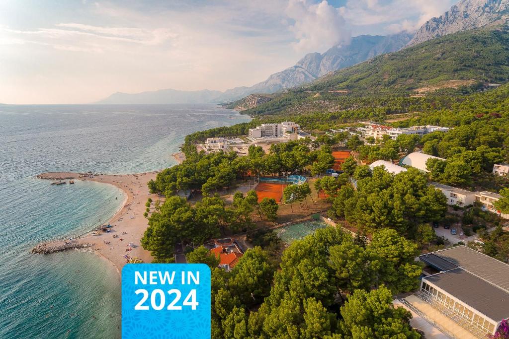 a new in sign next to a beach at Makarska Sunny Resort in Makarska