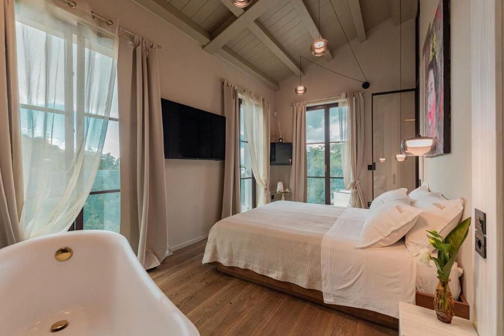 蒙蒂尼奧索的住宿－Tenuta Zamparina，卧室配有白色的床和浴缸