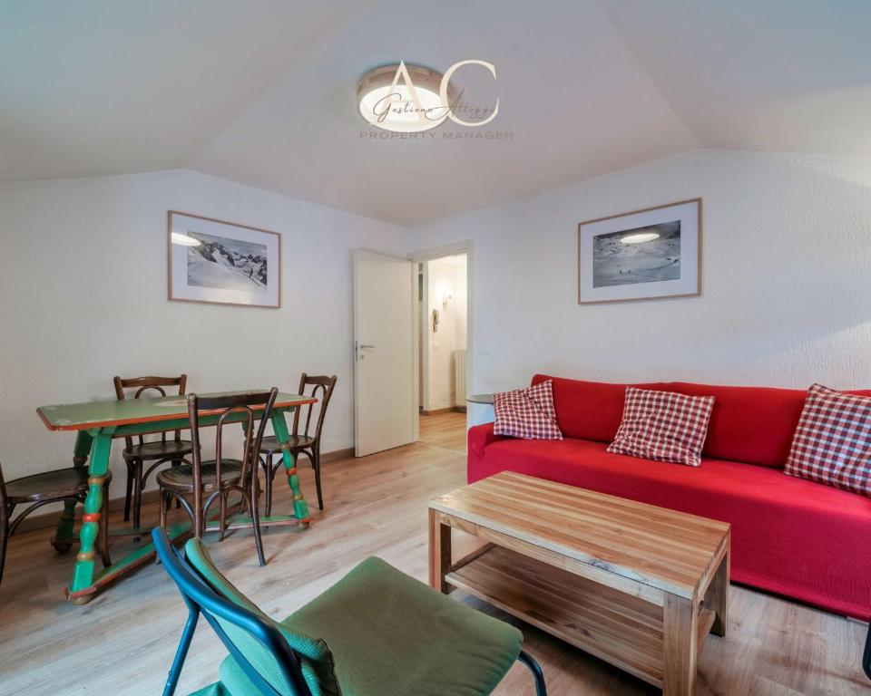 a living room with a red couch and a table at Square Apartment in Ponte di Legno