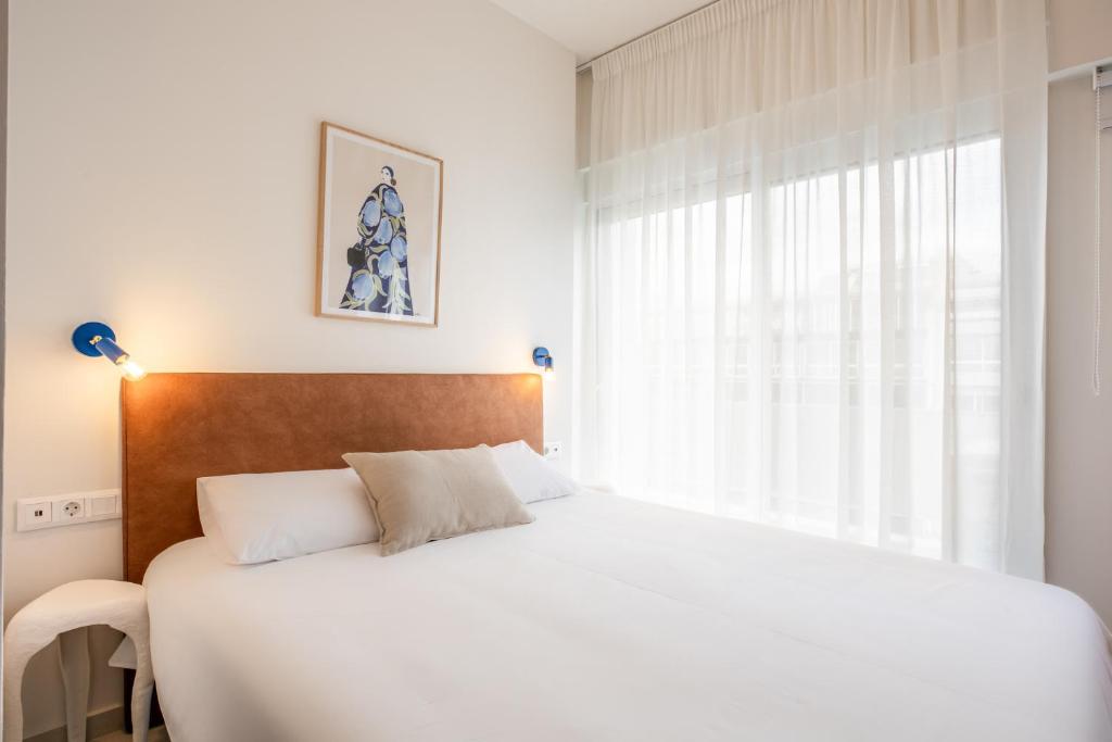 - une chambre avec un lit blanc et une fenêtre dans l'établissement Kallithea Apartments by Olala Homes, à Athènes