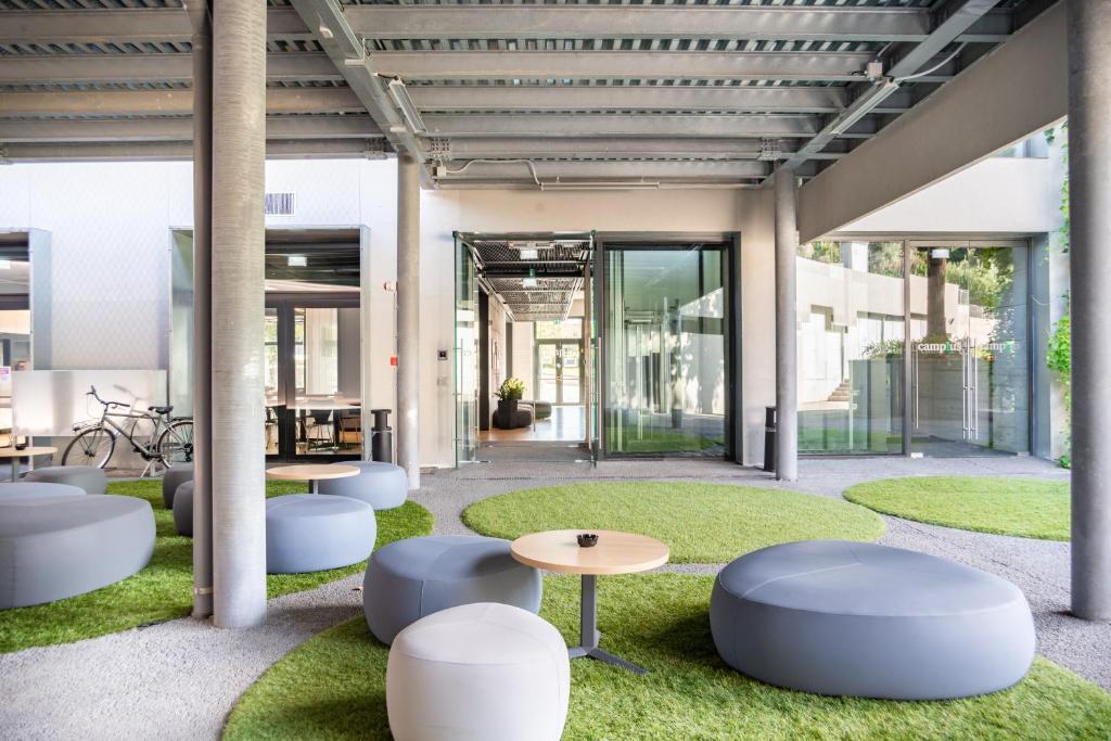 a lobby with white chairs and tables and grass at Camplus San Pietro in Rome