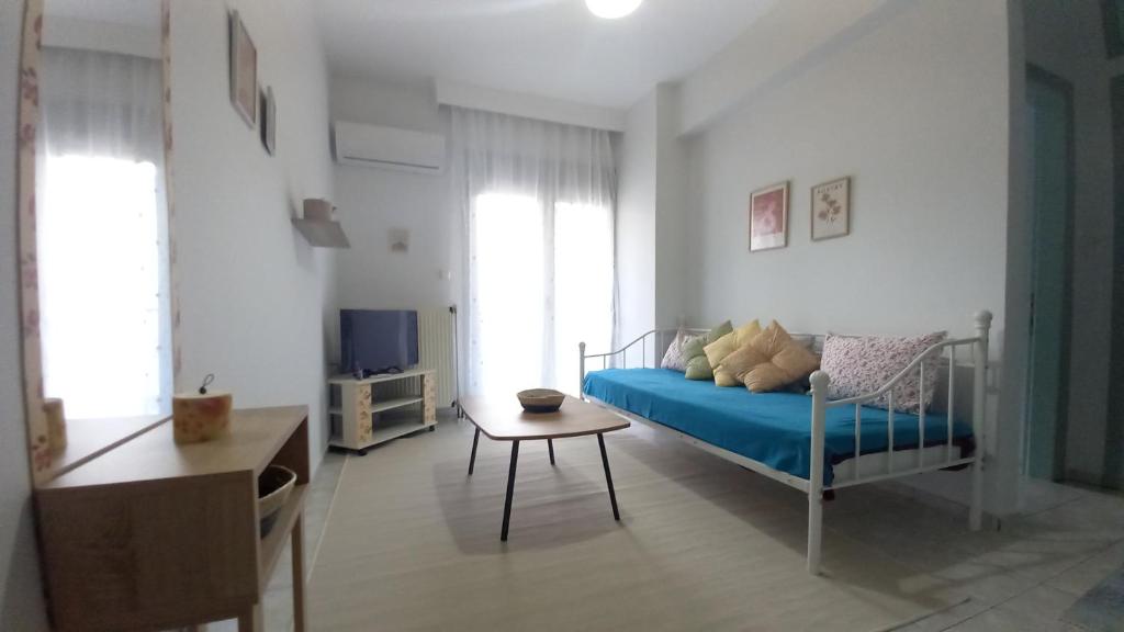 1 dormitorio con cama, mesa y TV en TasoulaSHome en Komotini