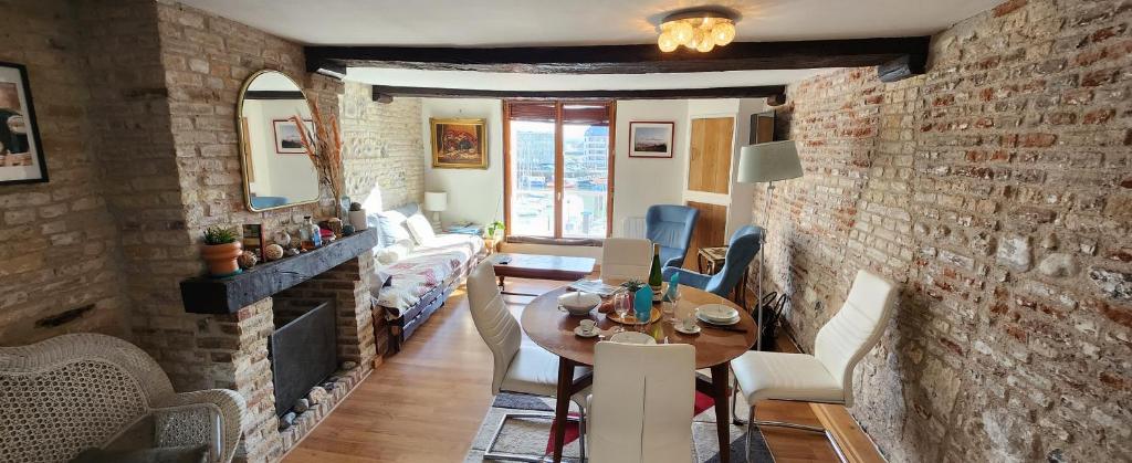 - un salon avec une table et un mur en briques dans l'établissement Dieppe Quai Henri IV, à Dieppe