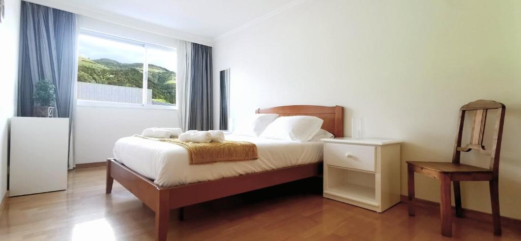 um quarto com uma cama e uma janela grande em Welcome Buddy - Santo Amaro Apartment em Vila Franca do Campo