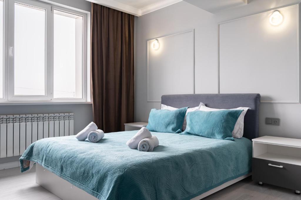 - une chambre dotée d'un lit bleu avec deux oreillers dans l'établissement One Bedroom Apartment Next To Arbat In The Heart of Almaty, à Almaty