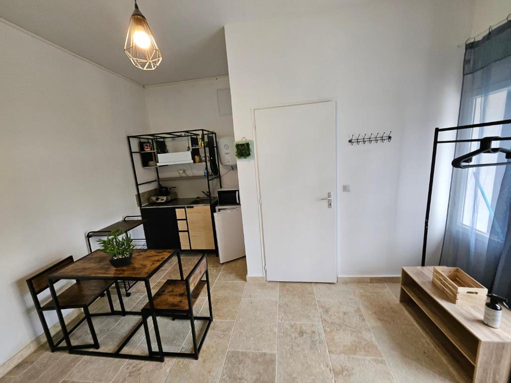 a living room with a table and a door at Gitedelatournelleauxerre in Auxerre