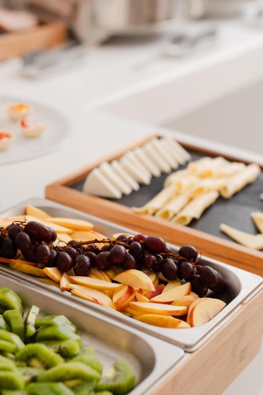 two trays of food with grapes and apples and cheese at White Dunes Luxury Boutique Hotel in Santa Maria