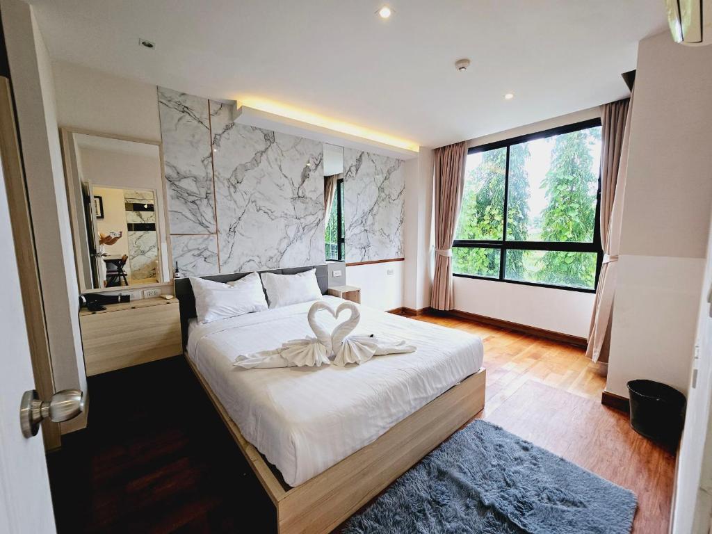una camera da letto con un letto e un asciugamano sopra di The Lago Naiharn by Sala Estate a Nai Harn Beach