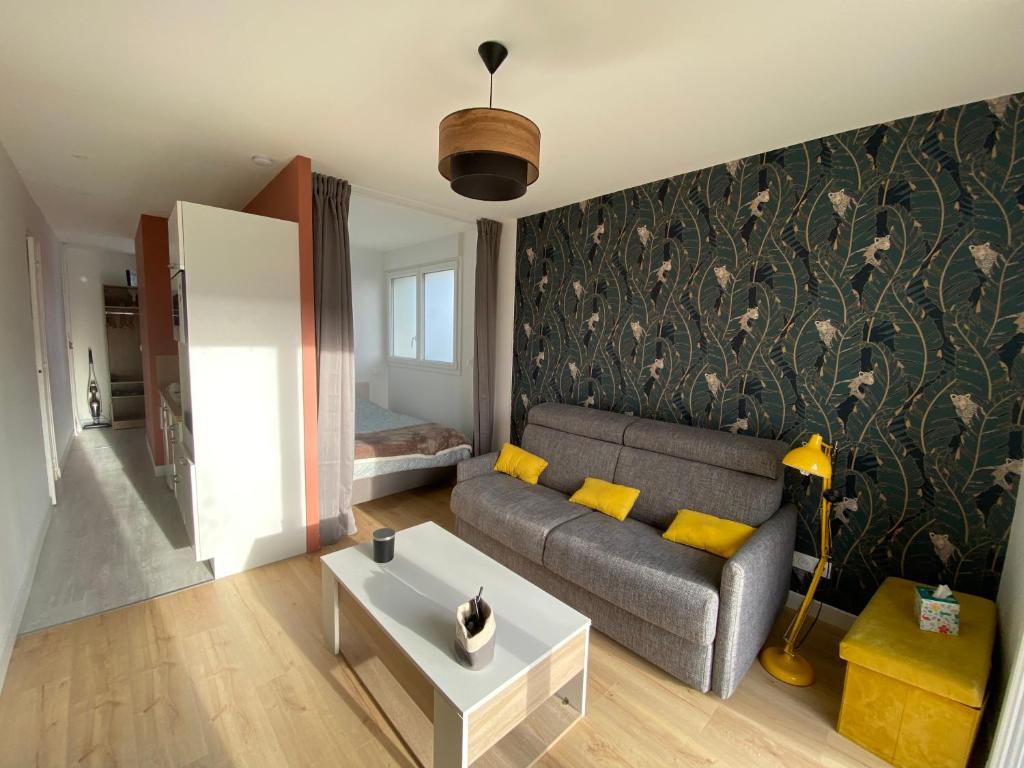 - un salon avec un canapé et une table dans l'établissement Appartement BIENVENUE au calme quartier Venoix, à Caen