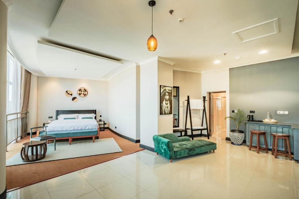 ein Schlafzimmer mit einem Bett, einem Sofa und einem Tisch in der Unterkunft Sanna Boutique Hotel in Arusha