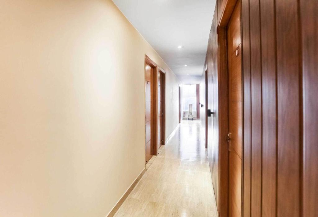 un couloir vide avec des murs en bois et un long couloir dans l'établissement OYO Flagship Hotel Paradise, à Indraprast
