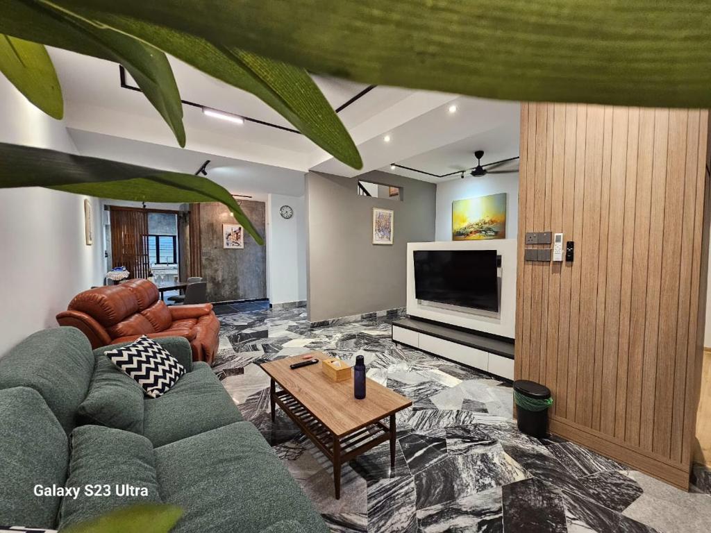 a living room with a couch and a tv at Traveler's Stay @ Ipoh (10Pax) in Ipoh