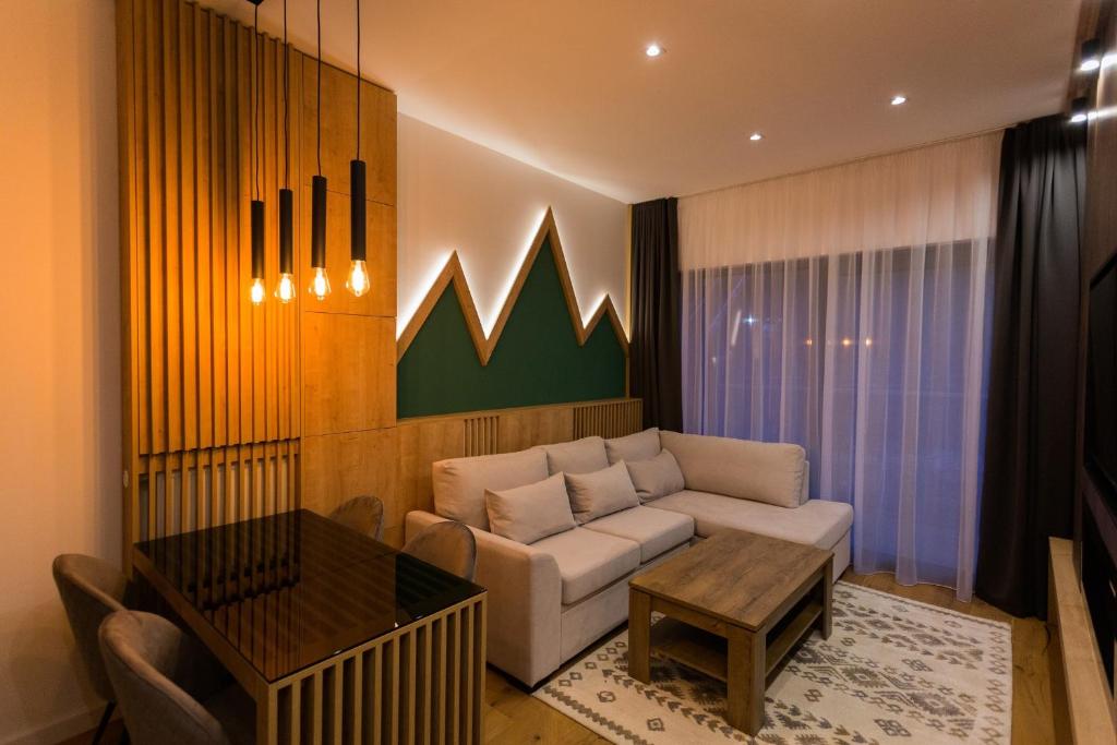 a living room with a couch and a table at Aparthotel Phoenix in Bjelašnica