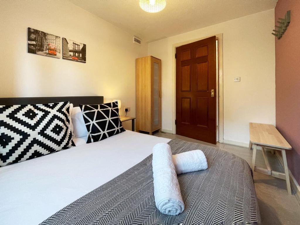 een slaapkamer met een bed en een houten deur bij Rebecca's Place at Whitechapel in Londen