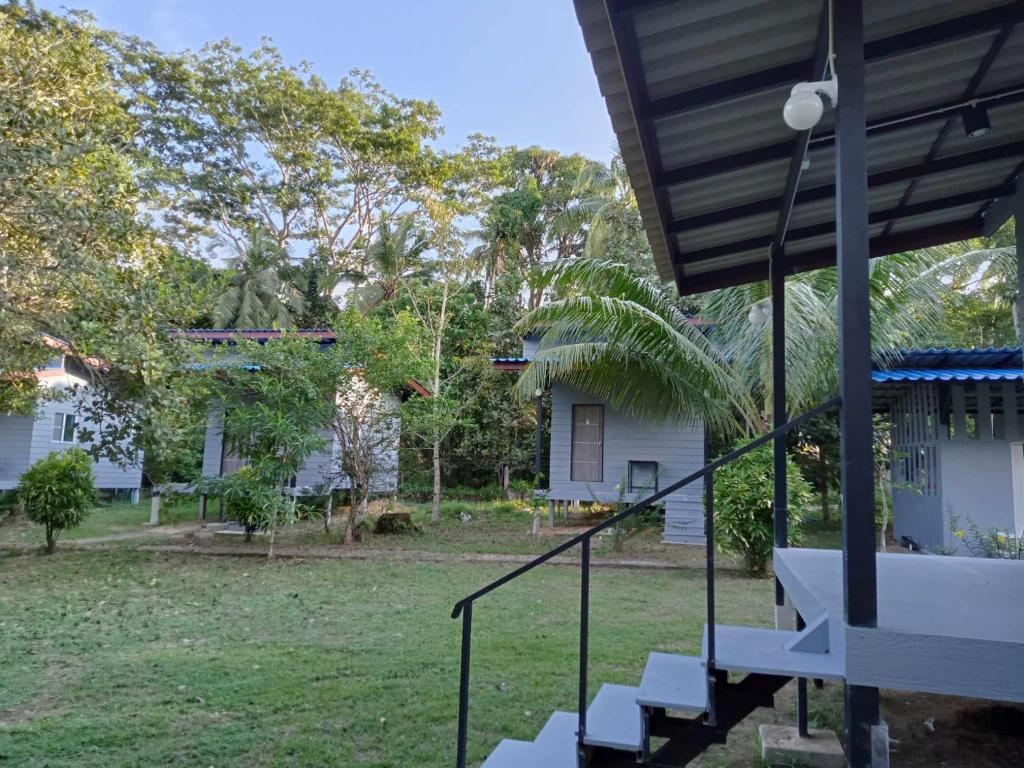 a porch of a house with stairs and trees at family resort in Ko Phayam