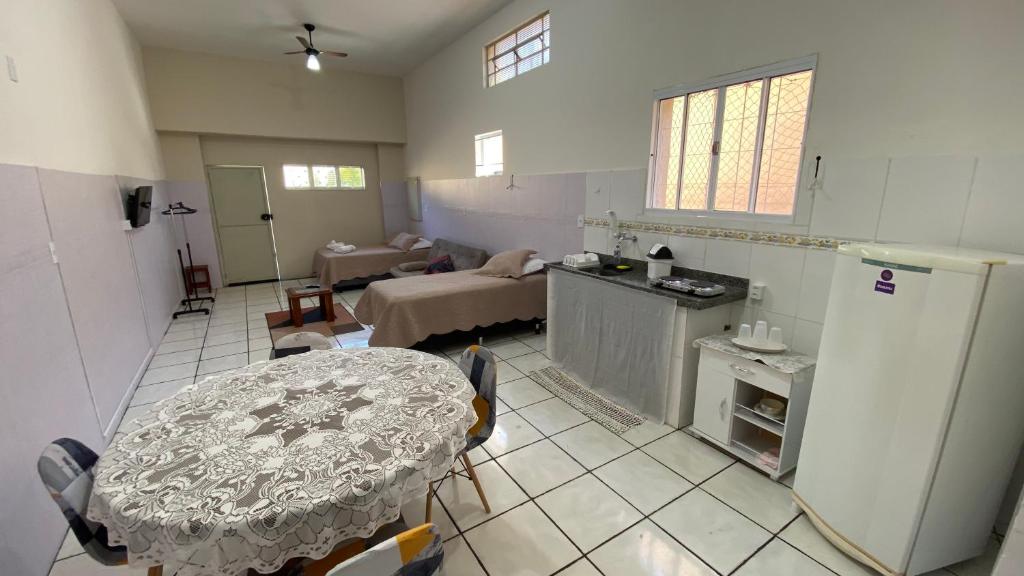 a kitchen and a living room with a table and refrigerator at Kitnet recanto do mosteiro in Ribeirão Preto