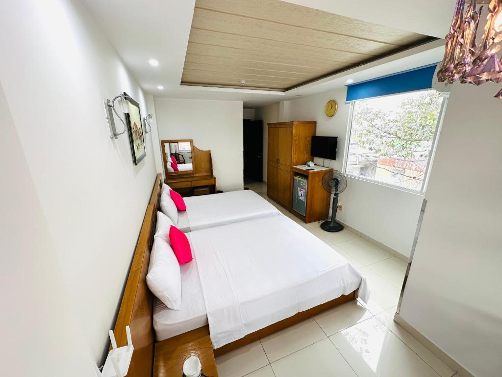 a bedroom with a bed and a window at REDFLOWER HOTEL in Ho Chi Minh City
