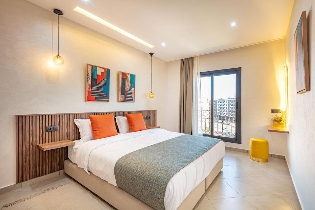 1 dormitorio con 1 cama grande con almohadas de color naranja en RA 35 by Majestic Properties, en Marrakech