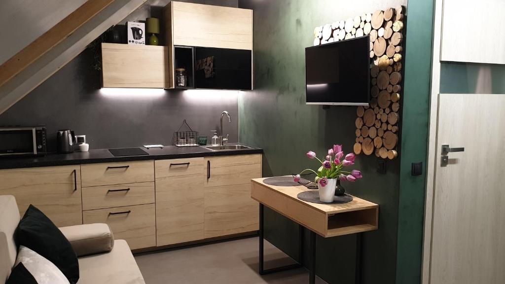 una cucina con tavolo e fiori di Apartament Natural ASD Studio a Wieliczka