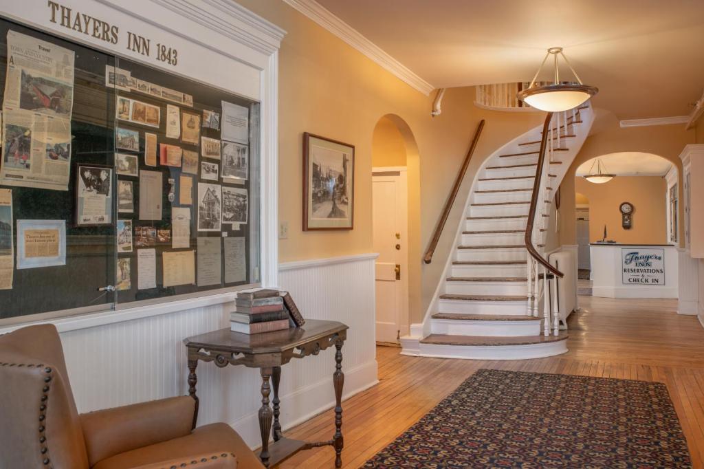 a hallway with a spiral staircase and a stairway with a table at Thayers Inn in Littleton