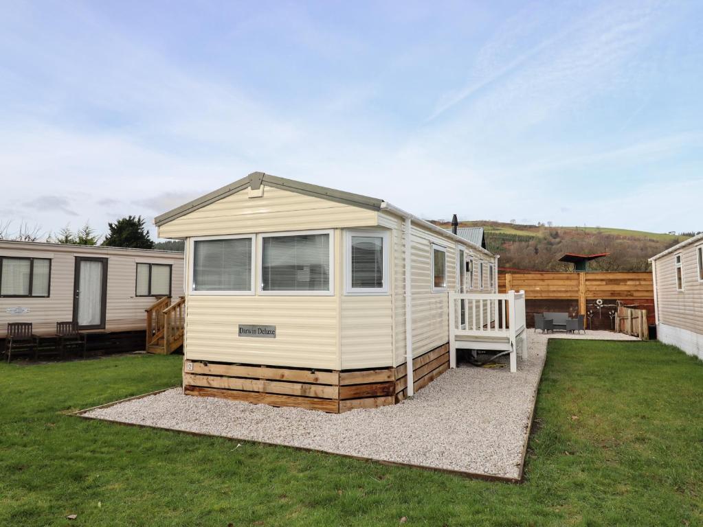 a tiny house is sitting on top of a yard at Berwyn View Holiday Home in Corwen