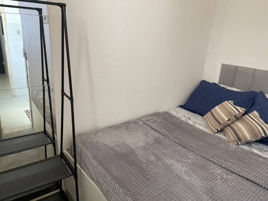 una camera da letto con un letto con uno specchio accanto di Loft funcional a Rio de Janeiro