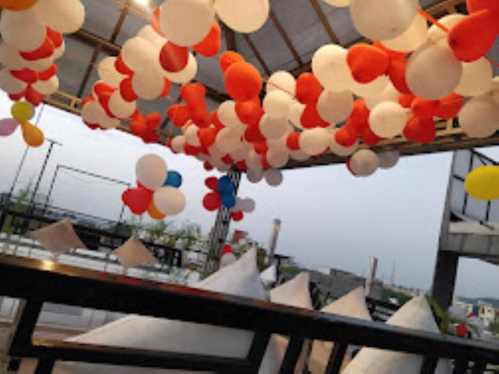 Un mucchio di palloncini colorati appesi a un soffitto di Hotel 100 Blu Madhya Pradesh a Sāgar